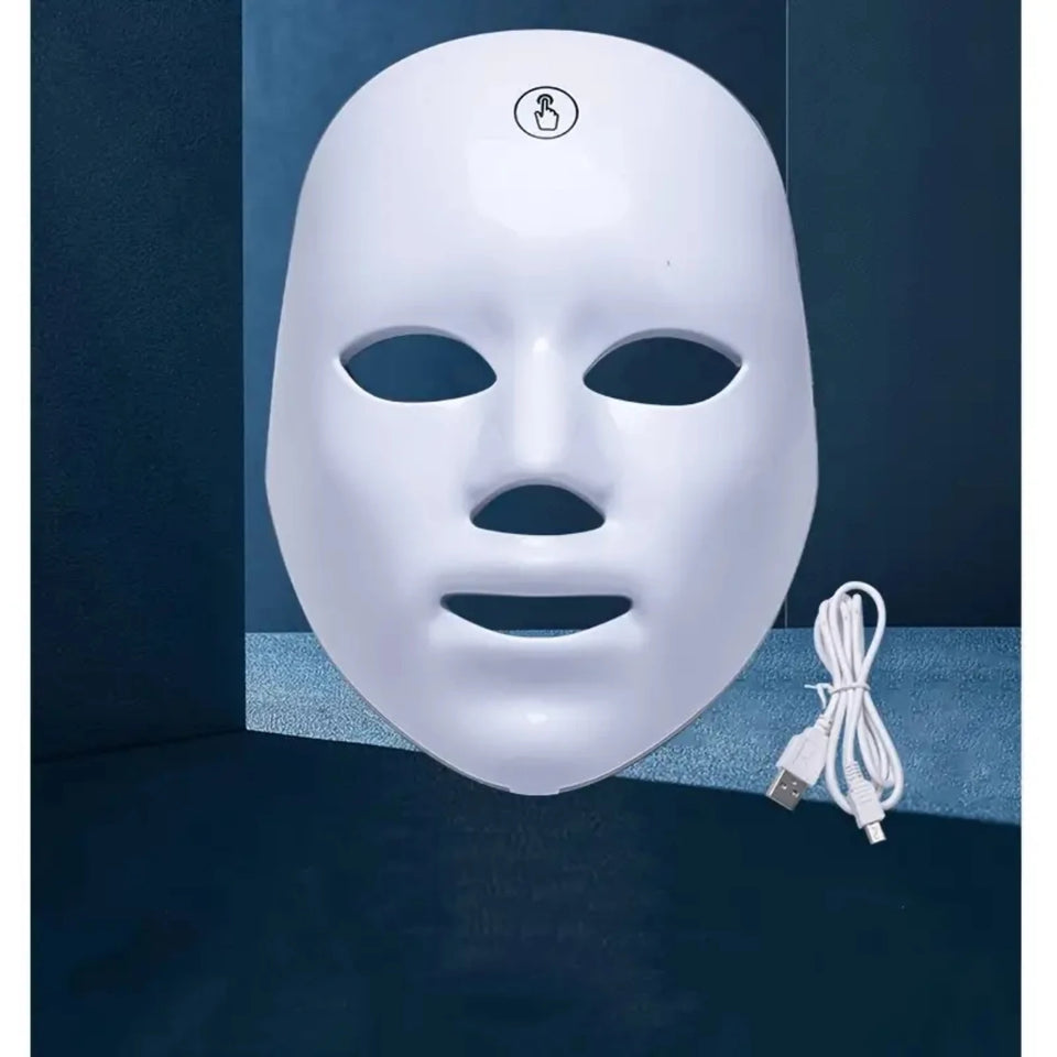 White 7 Color LED light therapy face mask for skin rejuvenation and anti-aging treatment, shown with a USB charging cable on a dark background, highlighting its use for home beauty and skincare